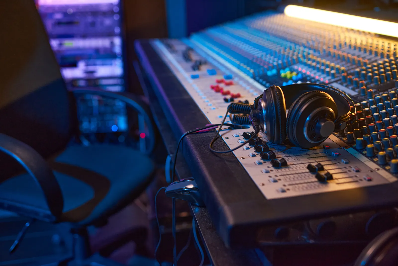 Studio monitors and open-back headphones on a mixing desk for mixing headphones vs studio monitors comparison